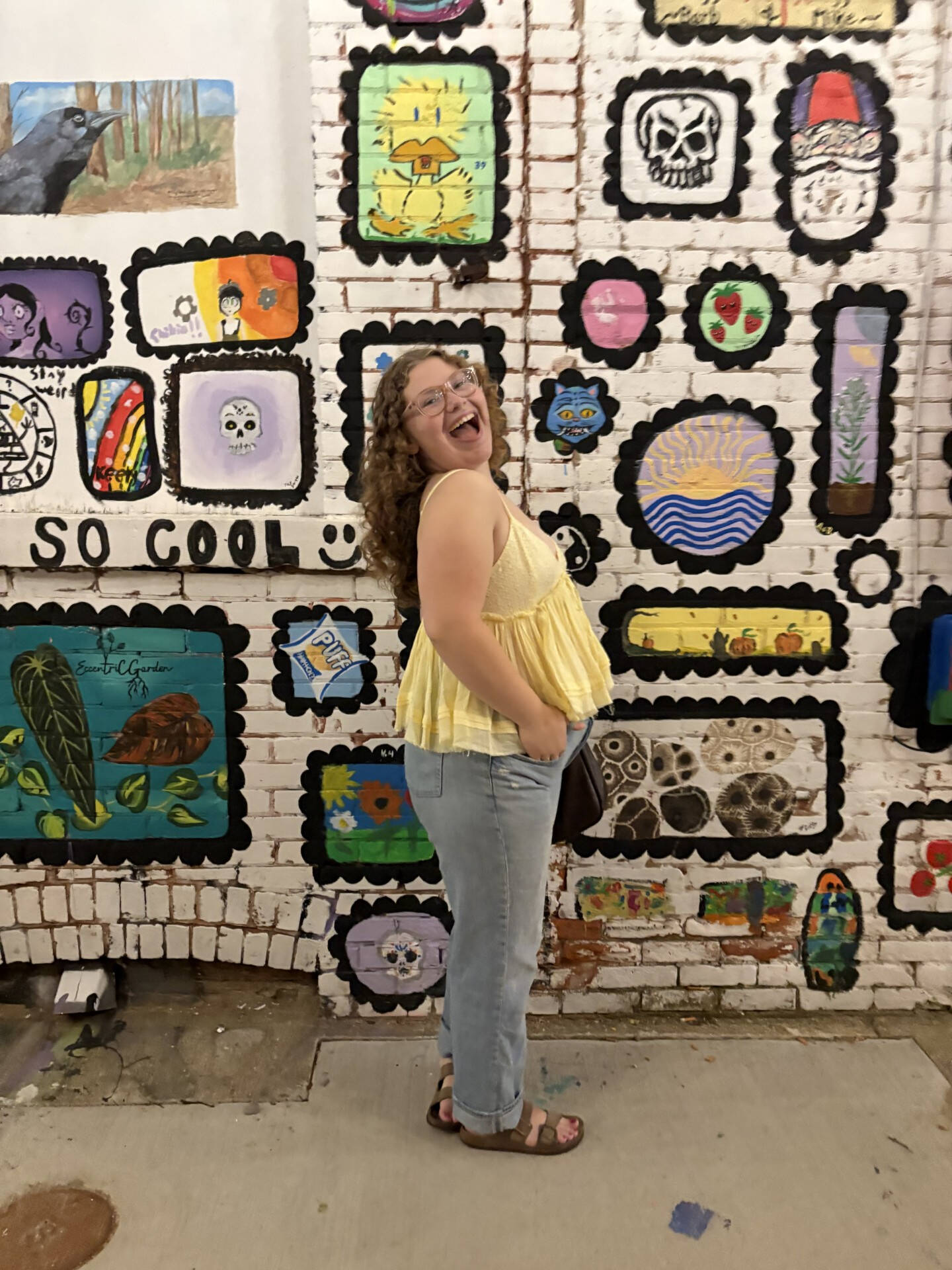 Chloe smiling in front of a cool wall